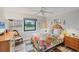 Bright bedroom boasts a colorful floral bedspread, ceiling fan, and beautiful natural light at 3955 Glen Oaks Manor Dr, Sarasota, FL 34232