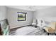 Comfortable bedroom with ceiling fan, wood-look flooring and a view of the landscaped yard at 3955 Glen Oaks Manor Dr, Sarasota, FL 34232