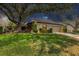 Charming single-story home with a lush front lawn and mature trees providing shade at 3955 Glen Oaks Manor Dr, Sarasota, FL 34232