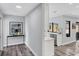 Bright hallway featuring modern decor, artwork, and wood-look floors at 3955 Glen Oaks Manor Dr, Sarasota, FL 34232