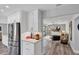 Modern kitchen with stainless steel refrigerator and view into the living area with contemporary decor at 3955 Glen Oaks Manor Dr, Sarasota, FL 34232