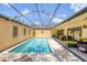 Relaxing private pool area featuring a screened enclosure, comfortable seating, and attractive landscaping at 3955 Glen Oaks Manor Dr, Sarasota, FL 34232