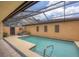 Inviting screened-in pool with a baja shelf, landscaping, and poolside seating at 3955 Glen Oaks Manor Dr, Sarasota, FL 34232