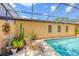 Tranquil pool area with a screened enclosure, mature landscaping, and a cozy wooden lounge chair at 3955 Glen Oaks Manor Dr, Sarasota, FL 34232