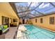 Private pool area featuring a screened enclosure, comfortable seating, tiled patio, and tropical plants at 3955 Glen Oaks Manor Dr, Sarasota, FL 34232