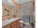 Well-lit bathroom with patterned shower curtain, colorful tile floor, and decorative accents at 4211 Kingsfield Dr, Parrish, FL 34219