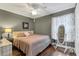 Bedroom featuring wood floors, large window with curtain, and a decorative mirror at 4211 Kingsfield Dr, Parrish, FL 34219