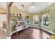 Office area with dark wood floors, two large windows, shelving unit, and green walls at 4211 Kingsfield Dr, Parrish, FL 34219