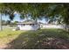 View of the home's backyard featuring a grass lawn and partial tree cover at 4229 Alna Way, Sarasota, FL 34232