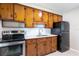 Kitchen with wood cabinets, white backsplash, stainless steel oven, and black refrigerator at 4229 Alna Way, Sarasota, FL 34232