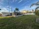 Expansive backyard with mature palm trees, lush green grass, and screen enclosed pool area at 4411 Dolphin Ln, Palmetto, FL 34221