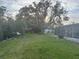 Spacious backyard with a screened in pool and mature trees providing shade at 4411 Dolphin Ln, Palmetto, FL 34221