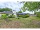 Spacious backyard featuring a screen-enclosed pool area, mature trees, and lush greenery at 4415 Charing Cross Rd, Sarasota, FL 34241