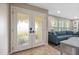 Sunlit living room featuring tiled floors and double-door entry at 4415 Charing Cross Rd, Sarasota, FL 34241