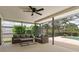 View of a screened patio with ceiling fan, outdoor furniture, and a glimpse of the pool beyond at 4415 Charing Cross Rd, Sarasota, FL 34241