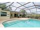Relaxing screened-in pool with sun-drenched deck, tile trim, and access to the home's interior at 4415 Charing Cross Rd, Sarasota, FL 34241