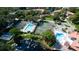 High-angle view showcasing a community's pool, tennis courts, and pond, set within a leafy, residential area at 4505 45Th W Ave # 101B, Bradenton, FL 34210