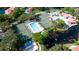 Overhead shot of community amenities including a pool, tennis courts, and pond, surrounded by verdant trees at 4505 45Th W Ave # 101B, Bradenton, FL 34210