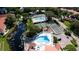 Aerial shot of community amenities, featuring a pool and tennis courts, framed by a picturesque pond and greenery at 4505 45Th W Ave # 101B, Bradenton, FL 34210