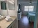 Bathroom with a view into the bedroom, featuring a vanity with storage and fresh towels at 4505 45Th W Ave # 101B, Bradenton, FL 34210