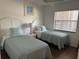Comfortable bedroom showcasing two twin beds, soft lighting, and a serene atmosphere at 4505 45Th W Ave # 101B, Bradenton, FL 34210