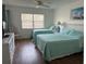 Inviting bedroom featuring two twin beds, a ceiling fan, and a large window with blinds at 4505 45Th W Ave # 101B, Bradenton, FL 34210