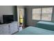 Bright bedroom features two twin beds, large window, and dresser with television at 4505 45Th W Ave # 101B, Bradenton, FL 34210