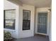 Exterior entryway featuring a gray door marked '101' and two windows that provide natural light at 4505 45Th W Ave # 101B, Bradenton, FL 34210