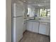 Well-lit kitchen featuring white cabinets, modern appliances, and tile flooring at 4505 45Th W Ave # 101B, Bradenton, FL 34210