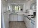 Bright kitchen with white appliances, tile floors, and a seamless view into the dining and living areas at 4505 45Th W Ave # 101B, Bradenton, FL 34210
