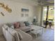 Bright living room features a large sectional sofa and sliding doors to the balcony at 4505 45Th W Ave # 101B, Bradenton, FL 34210