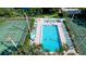 Aerial view of a pristine pool and tennis court area surrounded by lush landscaping at 4505 45Th W Ave # 101B, Bradenton, FL 34210