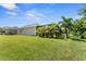 Lush backyard featuring well-maintained lawn, screen enclosed pool, and mature landscaping at 4515 Roycroft Ter, Parrish, FL 34219