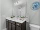 Bathroom featuring a vanity with white countertop, wood cabinets, and a decorative mirror at 4515 Roycroft Ter, Parrish, FL 34219