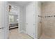 Bathroom with a tile shower, linen closet, and doorway leading to bedroom at 4515 Roycroft Ter, Parrish, FL 34219
