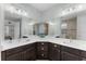 Double vanity bathroom with modern lighting, large mirrors and a tiled walk-in shower at 4515 Roycroft Ter, Parrish, FL 34219