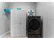 Laundry area with a modern black washer and dryer unit, complemented by a linen closet at 4515 Roycroft Ter, Parrish, FL 34219
