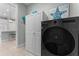 Laundry area with a modern black washer and dryer unit, complemented by a linen closet at 4515 Roycroft Ter, Parrish, FL 34219