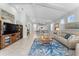 Spacious living area featuring an open layout with modern furniture and seamless flow to the kitchen and dining space at 4515 Roycroft Ter, Parrish, FL 34219