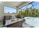 Screened patio featuring comfortable seating around a fire pit, overlooking the sparkling pool at 4515 Roycroft Ter, Parrish, FL 34219