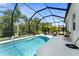 Beautiful pool and spa area surrounded by lush landscaping and a screened enclosure at 4515 Roycroft Ter, Parrish, FL 34219