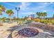 Community pool area with a fire pit, lounge chairs, slide, and lush landscaping at 4515 Roycroft Ter, Parrish, FL 34219