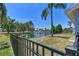Fenced backyard with view of the pond, palm trees, and lawn at 4604 9Th E Ave, Bradenton, FL 34208