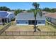Fenced backyard features green grass and a large palm tree, providing privacy and a tropical touch at 4604 9Th E Ave, Bradenton, FL 34208
