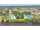 Aerial view of the community featuring a pool, tennis court, and picturesque lakes in a serene setting at 4604 9Th E Ave, Bradenton, FL 34208