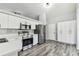 Modern kitchen with stainless steel appliances, sleek white cabinets, and wood-look floors at 4604 9Th E Ave, Bradenton, FL 34208