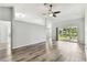 Spacious living room featuring a ceiling fan, wood-look floors, and sliding glass doors at 4604 9Th E Ave, Bradenton, FL 34208