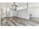 Open-concept living room with wood-look floors, ceiling fan, and view of bar seating area at 4604 9Th E Ave, Bradenton, FL 34208