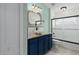 Beautiful bathroom featuring a vanity with dark blue cabinets and glass door shower and tub at 5209 Lansdowne Way, Palmetto, FL 34221