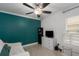 Bedroom with a teal accent wall, a ceiling fan, and a bright window at 5209 Lansdowne Way, Palmetto, FL 34221